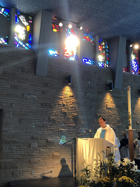 April 28   Beauty in the moment...the moment of a young man's first celebration of the Mass as a newly ordained priest while he delivers his first homily, the moment of the morning sun breaking through the stained glass to add a special feeling to this moment and memory.