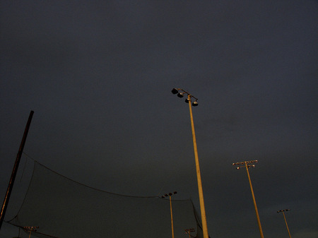 Baseball field light poles at sunset.