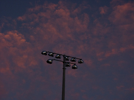 Athletic field light poles at sunset.