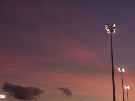 Soccer field light poles at sunset.