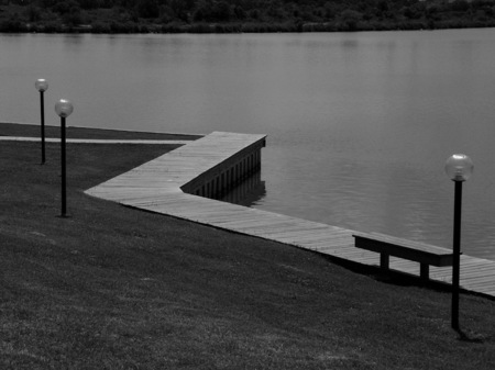 Apartment board walk with a solitary bench.