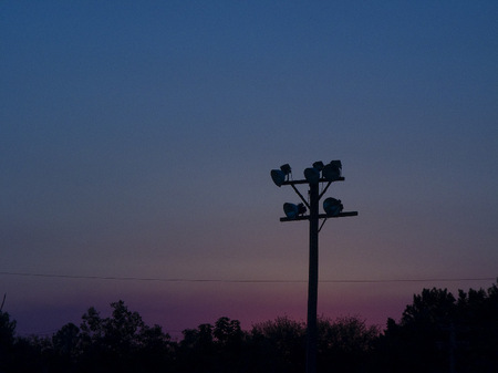 Athletic field light pole at dusk.