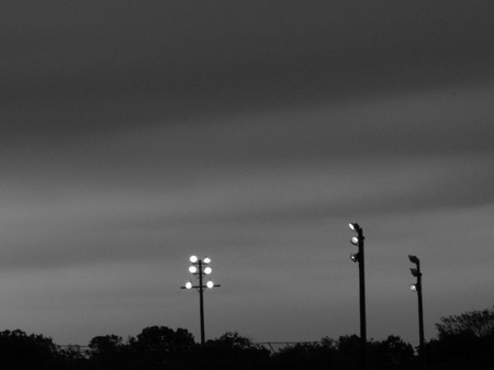 Little league light poles at dusk.