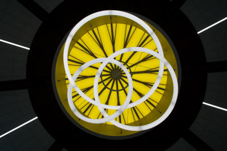 April 7  I look up before heading up the elevator to the airport terminal and this new art piece in the ceiling captures my attention. The beautiful colors and forms made of materials and light give me pause to reflect on the look and the artist who created it.