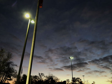 December 12  Arriving early to provide a motivational message to a nearby Kiwanis Club, I had to pause in the parking lot to appreciate the beauty of morning light greeting electrical light.
